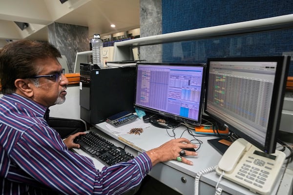 A stock broker checks indexes and benchmark 100 index at the Pakistan Stock Exchange (PSE), in Karachi, Pakistan, Monday, April 7, 2025. (AP Photo/Fareed Khan)