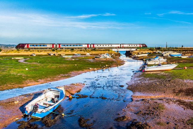 A CrossCountry class 220 Voyager train passing through the harbour at Cockwood on the Exe Estuary.