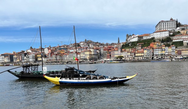 Wooden boats on a river with a city in the background