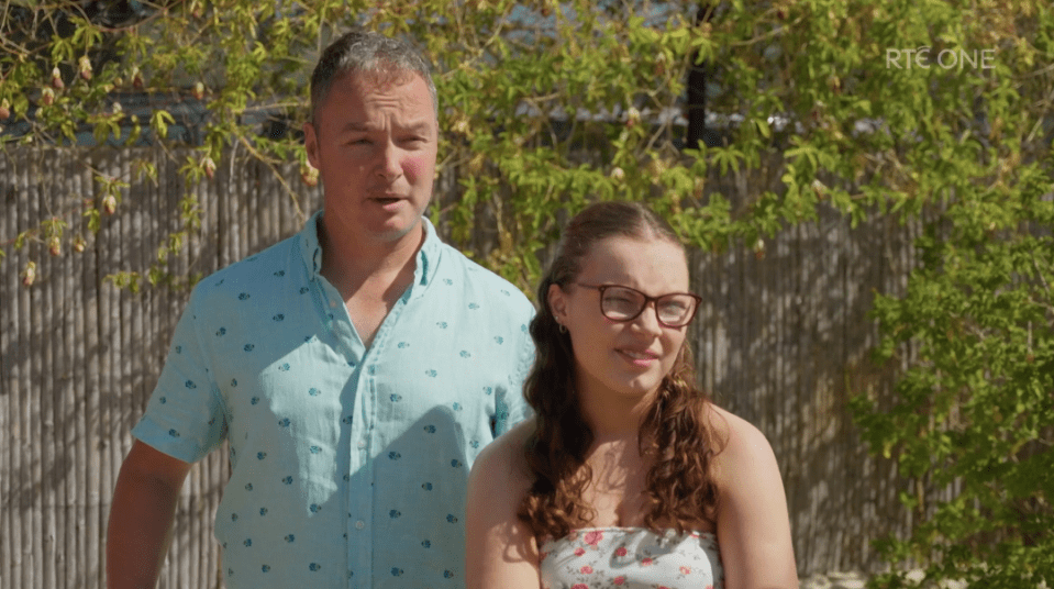 Screenshot of a man and a woman standing outdoors.