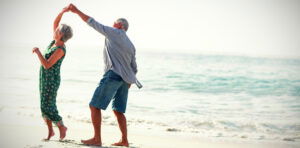 Senior couple dancing at beach on sunny day. Credit: vectorfusionart,  Shutterstock. 