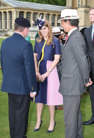 Princess Beatrice speaking to men at a Buckingham Palace garden party in 2016