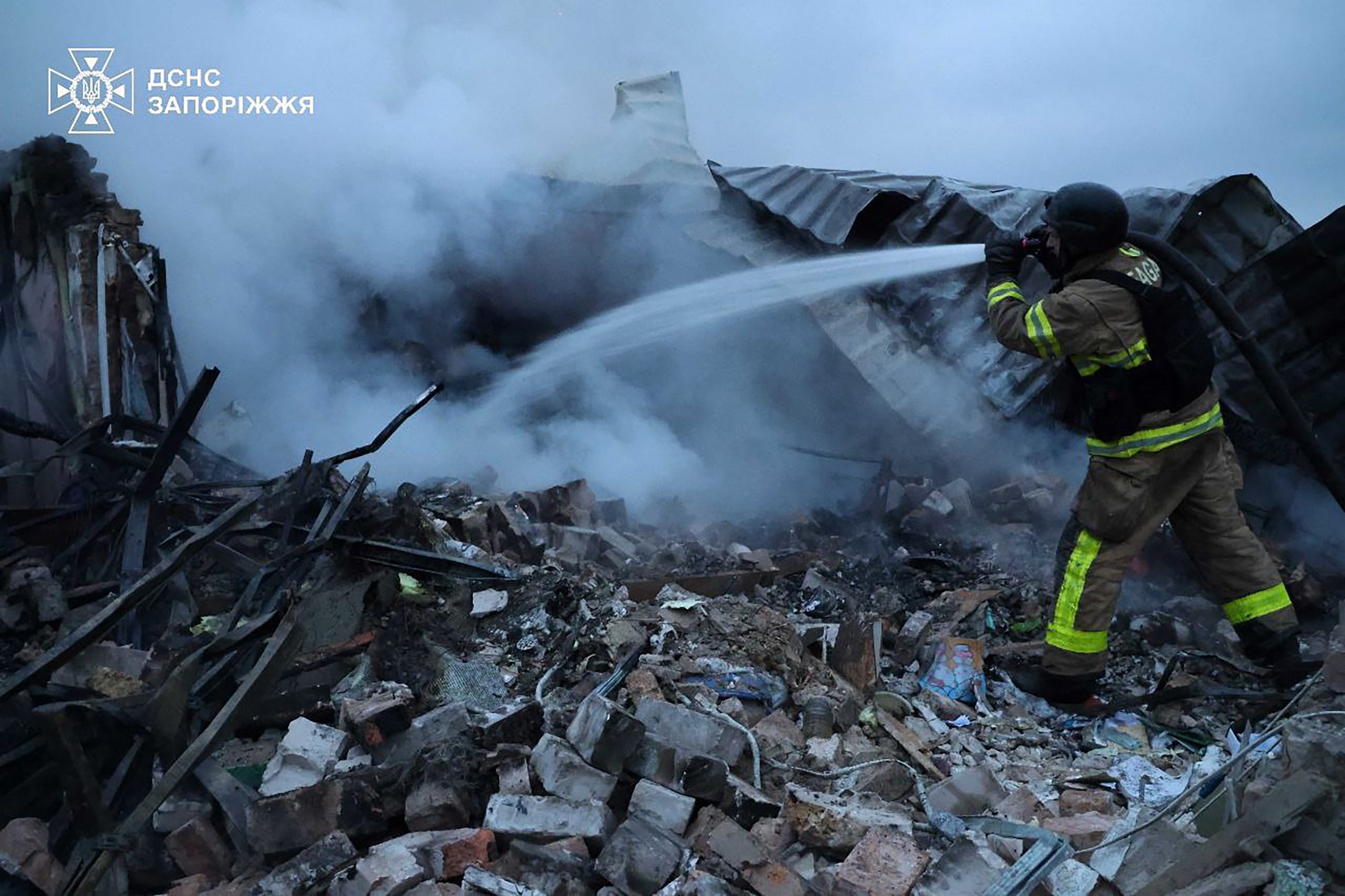 A Ukrainian firefighter extinguishes a fire after Russia fired an aerial guided bomb (KAB) in the Zaporizhzhia region