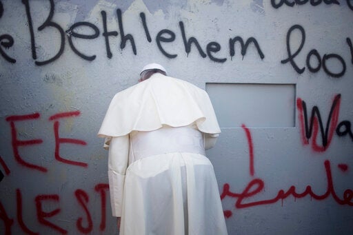 Pope Francis prays at Israel's separation barrier on his way to a mass in Manger Square next to the Church of the Nativity, in the West Bank city of Bethlehem in 2014