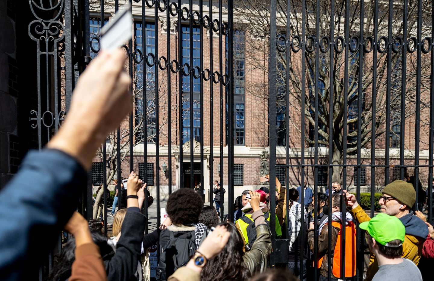 Protesters showed their Harvard IDs as university security guards tried to close a gate during a rally on Tuesday.
