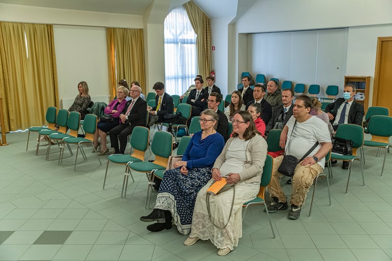 People watch a TV broadcast of general conference shown in Slovenianin in a church building in Ljubljana, Slovenia.