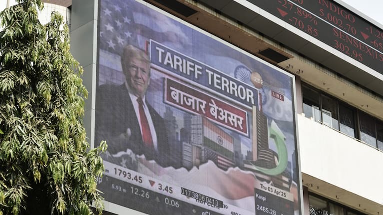 A broadcast screen at the Bombay Stock Exchange (BSE) in Mumbai, India, on April 3, 2025, displays news of U.S. President Donald Trump announcing sweeping new trade tariffs. 