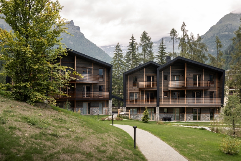 G22 projects tucks mountain village lodges amid northern italy's alpine peaks