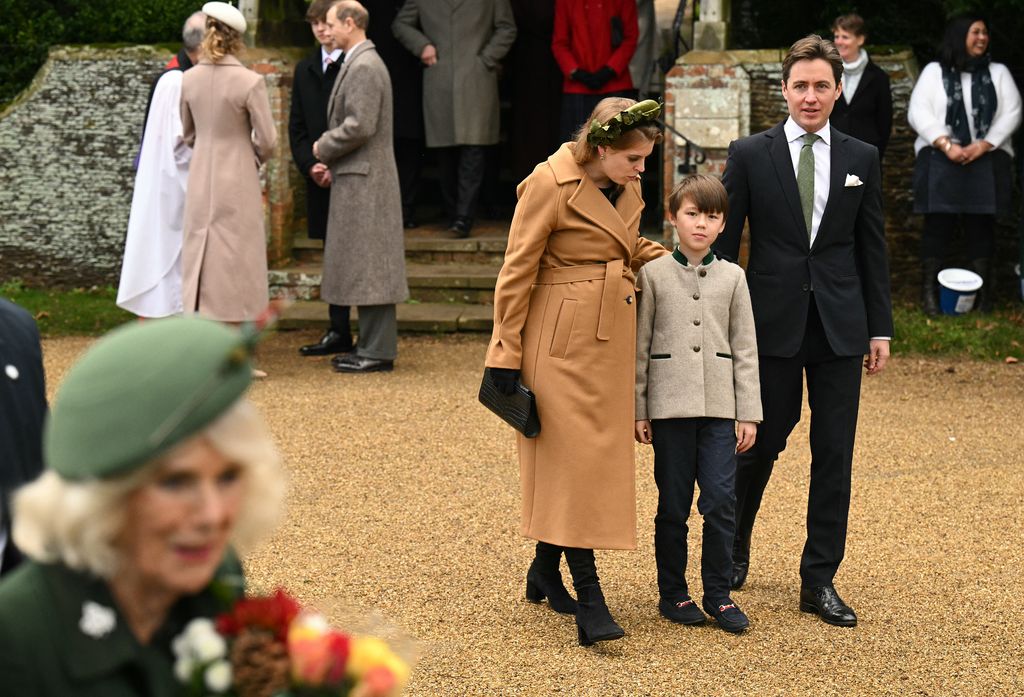 Beatrice leaning over to talk to Wolfie while walking with her husband after church service in Sandringham