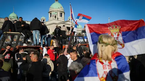 Getty Images Supporters of Serbia's President hold national flags during a pro-government rally in Belgrade