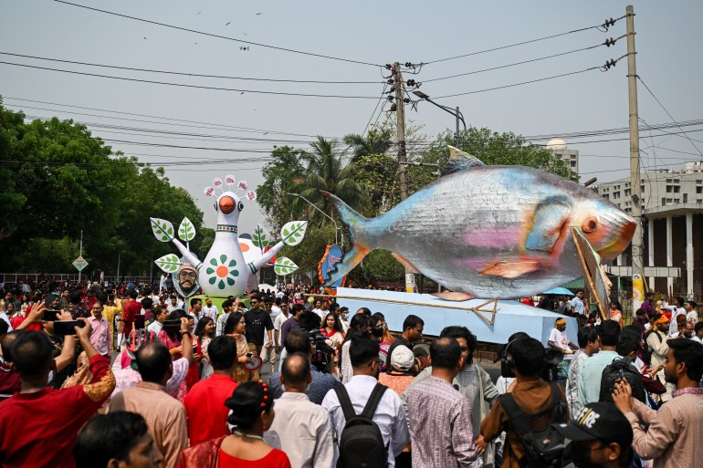 People march down a street during celebrations marking the 'Bengali New Year' in Dhaka on April 14, 2025. (Photo by MUNIR UZ ZAMAN / AFP)