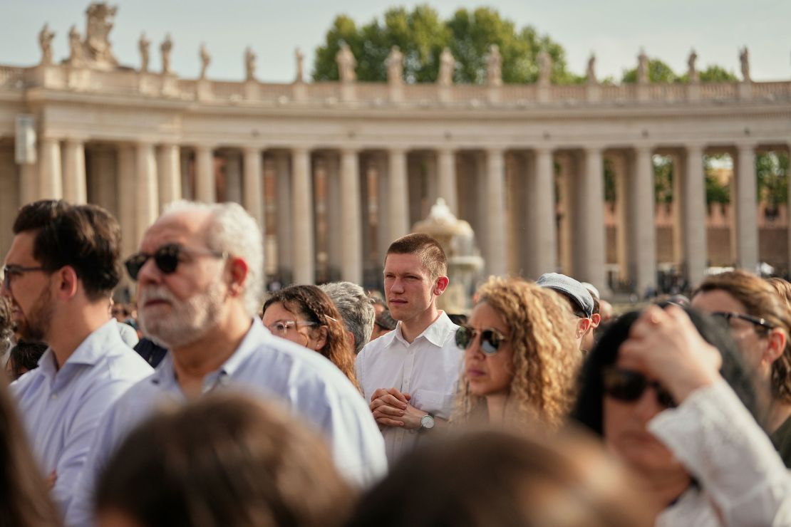 People gather in St. Peter's Square as they await the arrival of the body of Pope Francis.