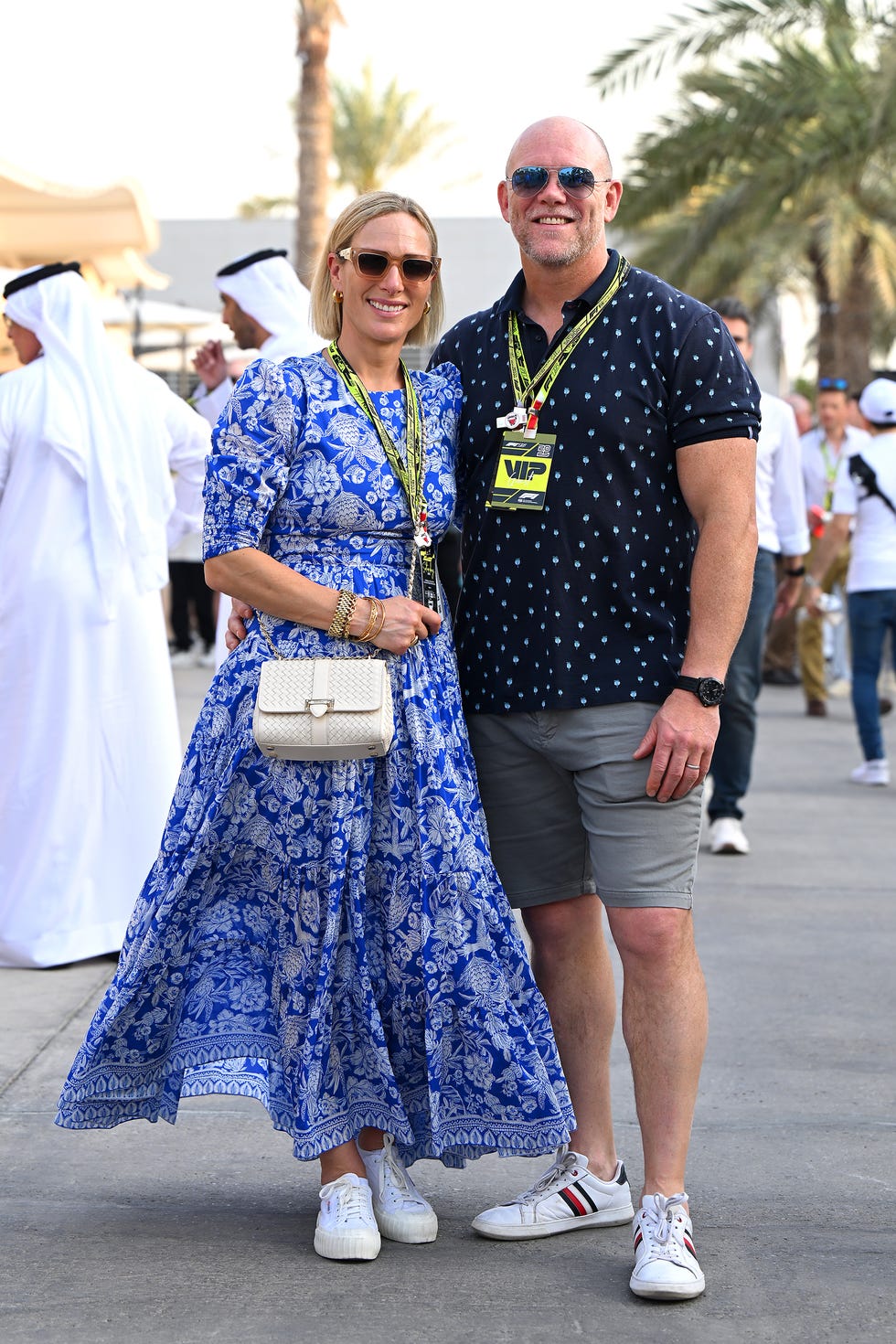 Couple posing together at a public event with VIP lanyards.