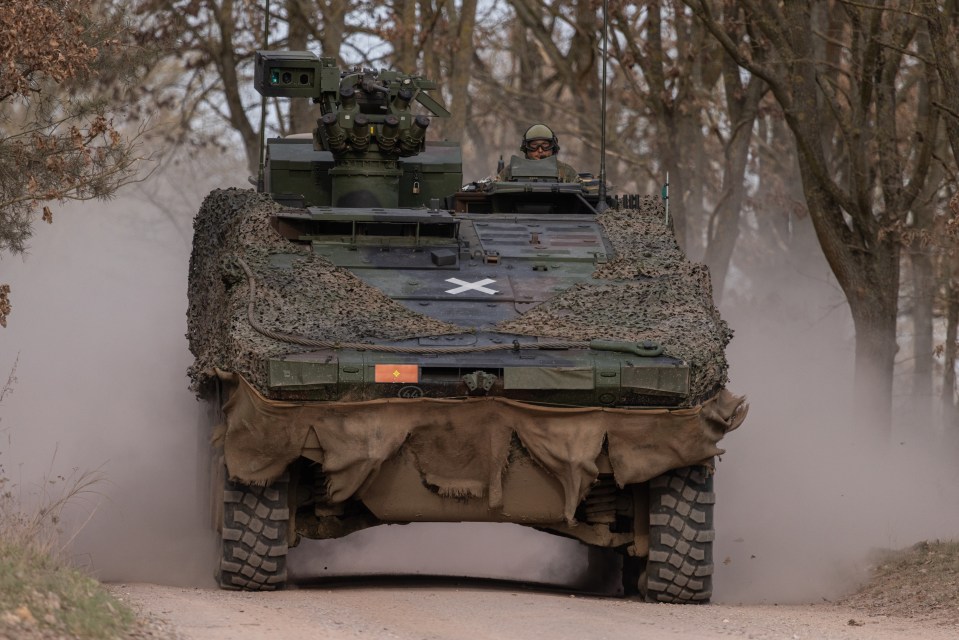 Boxer armored fighting vehicle driving on a dirt road.