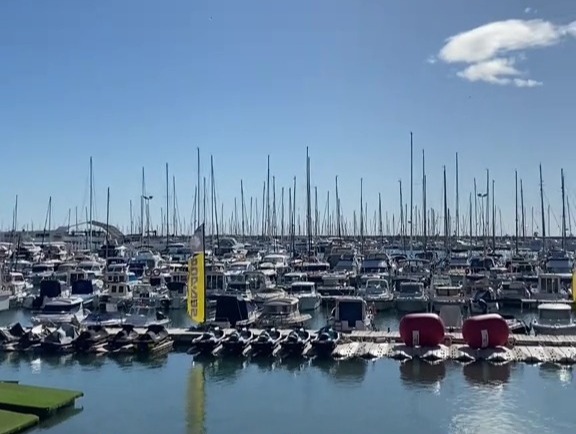 Photo of a marina with many boats, under a clear blue sky; text overlay reads "Prioritise YOU for a change" and "How does that sound? Read caption below".