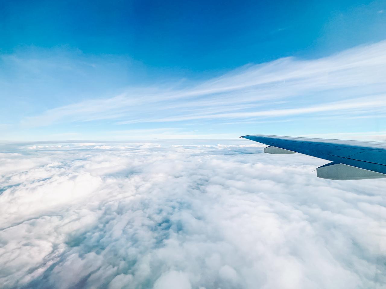 Wing of a plane flying above the clouds
