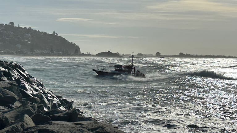 Coastguard's Sumner Blue Arrow brings two rescued men to shore after their boat capsized off the Banks Peninsula in Christchurch.