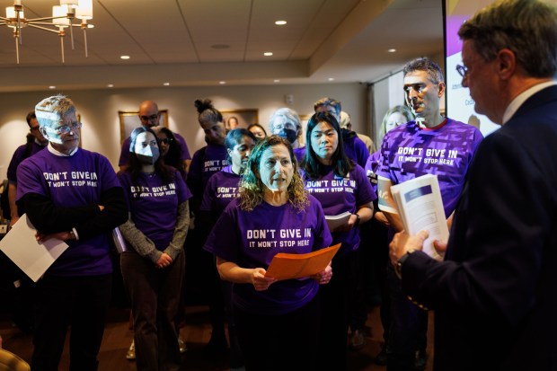 Julie Biehl, clinical professor of law at Northwestern University, gives Peter Barris, chair of the board of trustees, was given on April 9, 2025, a packet of letters of support from law professors, legal organizations and alumni across the country asking the university to take stand against the federal government. (Armando L. Sanchez/Chicago Tribune)