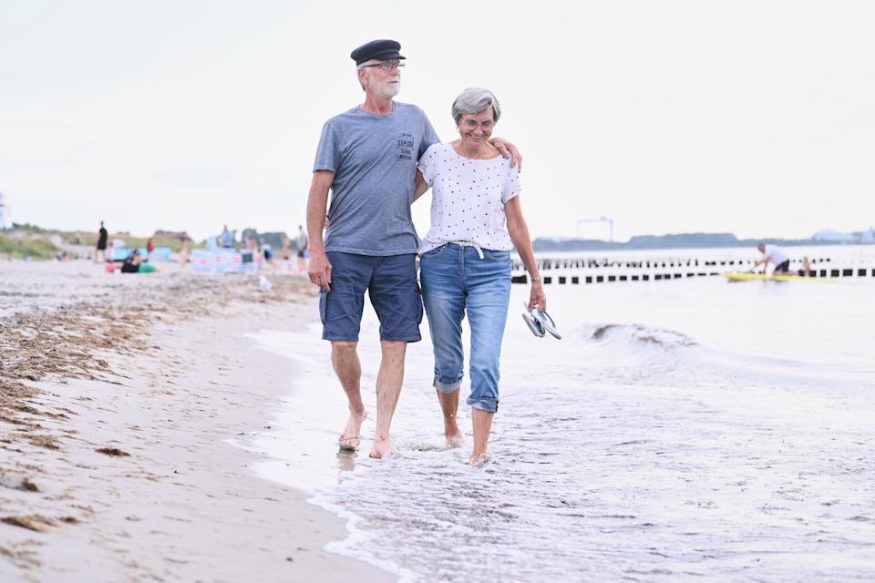 Older couple walking along beach
