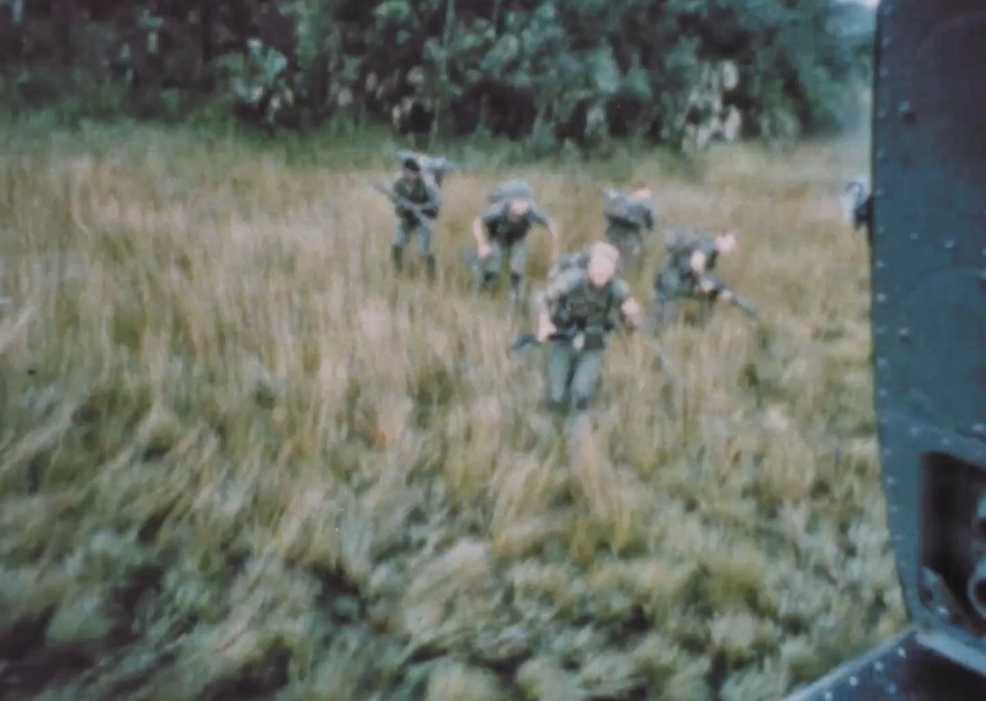 Huey door gunner sweeps the treeline with his M60 as what appears to be a Long-range reconnaissance patrol is evacuated in Vietnam