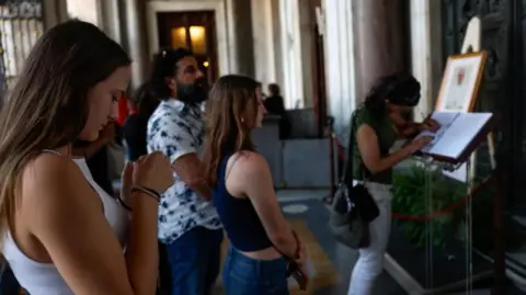 Reuters People writing in a book of condolences for Francis in the Santa Maria Maggiore 