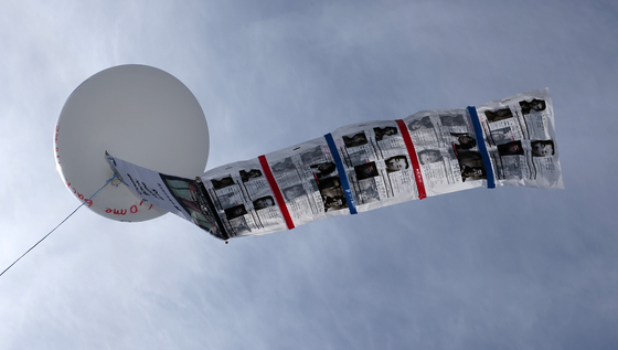 Leaflets aimed at North Korea flutter from a large balloon during the ″Safe Return Memorial Ceremony″ hosted by the Families of Abductees to North Korea Association near Peace Land at Imjingak in Paju, Gyeonggi on April 23. [NEWS1]