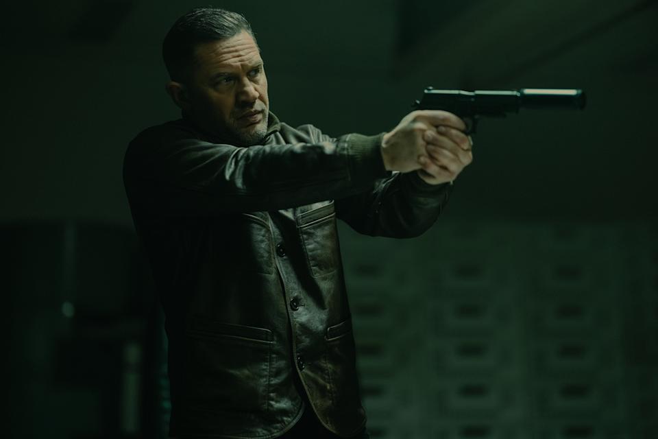 Tom Hardy points a gun in a scene from MobLand.