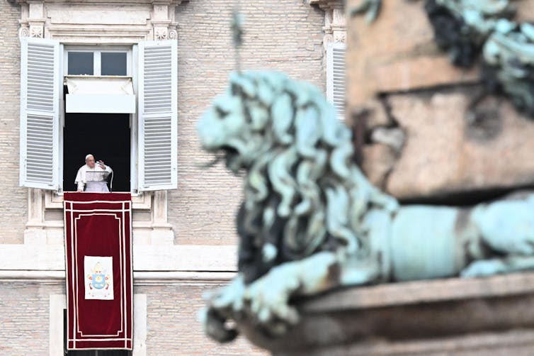 A photo of Pope Francis leading a prayer from the window of his office in the Vatican.