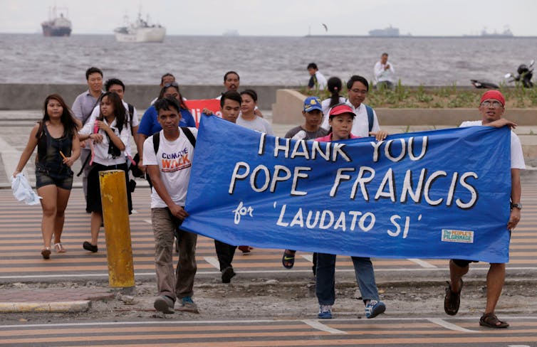 People hold 'Thank you pope francis, Laudato Si' banner