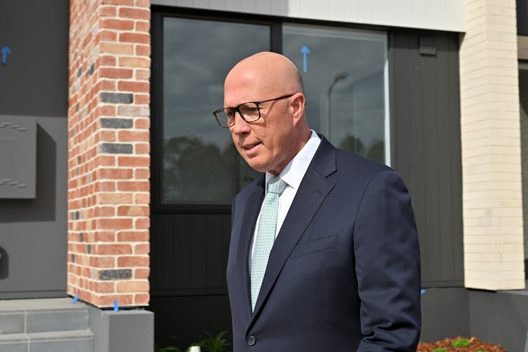 man in suit outside new house