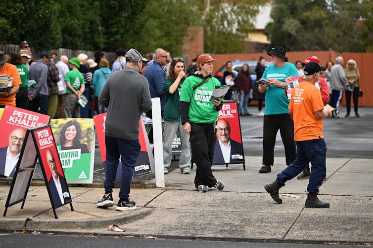 people standing outside polling booths