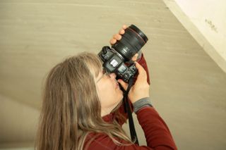 A female photographer using a camera to shoot interiors in modern surroundings