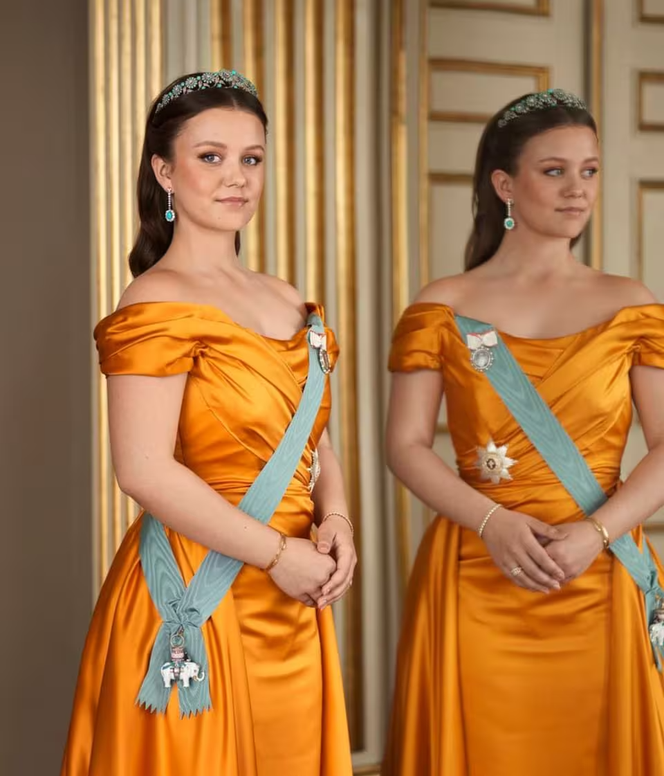 Princess Isabella wearing a gold gown and tiara standing in a mirror on her 18th birthday