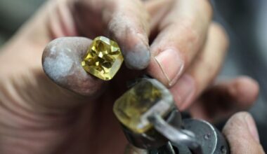 A worker holds a cut diamond in the manual polishing unit at the Antwerp World Diamond Center in Antwerp, Belgium