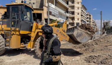 A fighter stands near ongoing roadworks in Aleppo, Syria