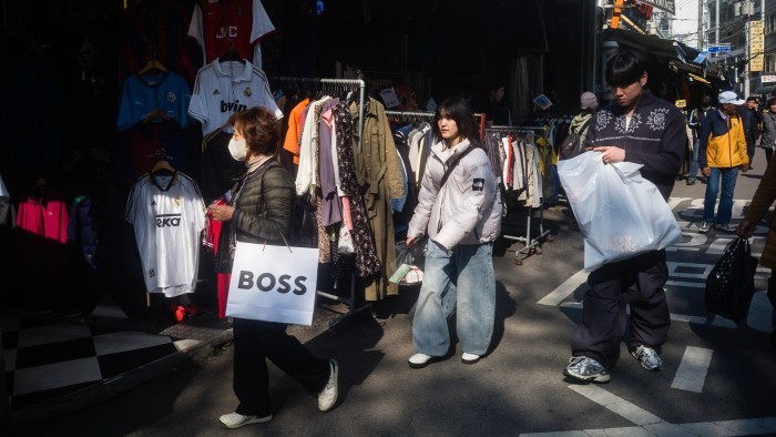 Shoppers walk with their bags at the Dongmyo Flea Market in Seoul