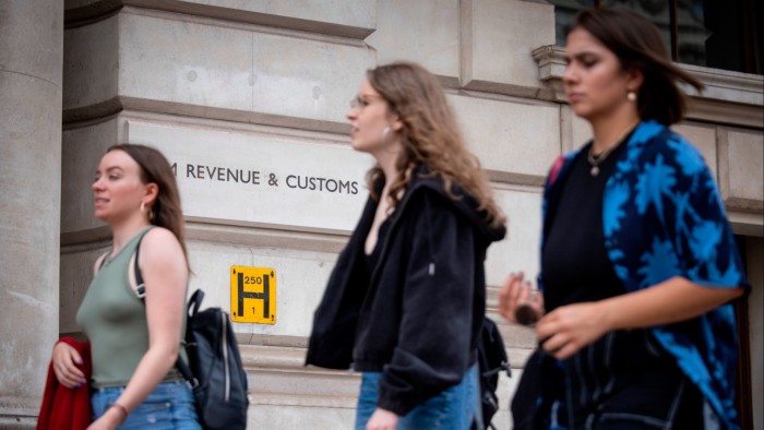 Young people walk by the HM Revenue and Customs building