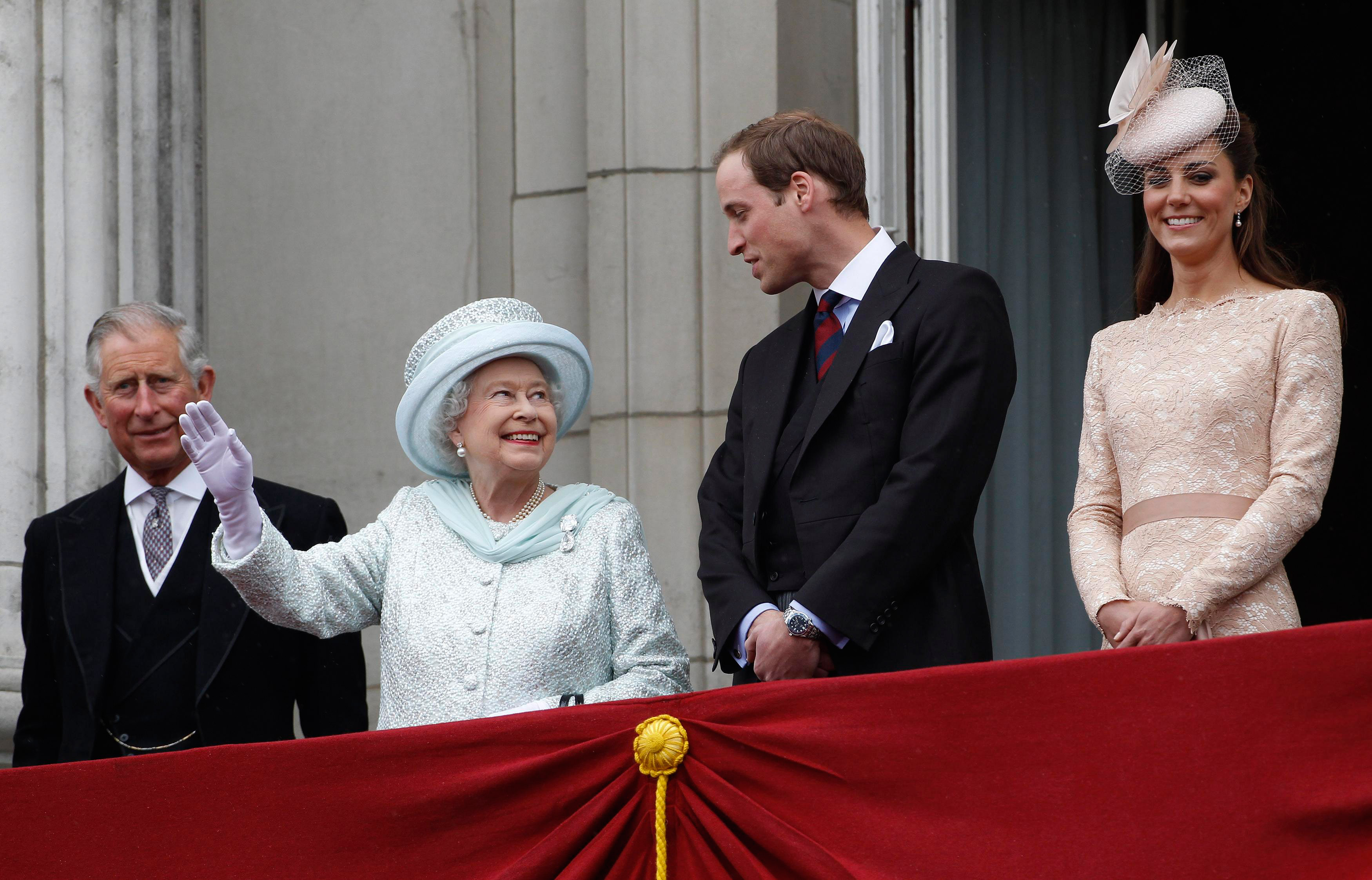 Queen Elizabeth waving from the balcony at Buckingham Palace with Prince Charles, Prince William and Kate Middleton in 2012