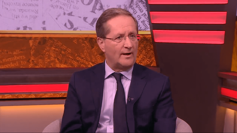 Man in suit speaking on television.