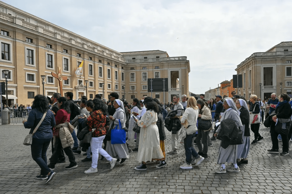 Crowd of people walking in St. Peter's Square.
