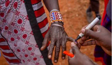 A person marks finger nail of an indigenous person