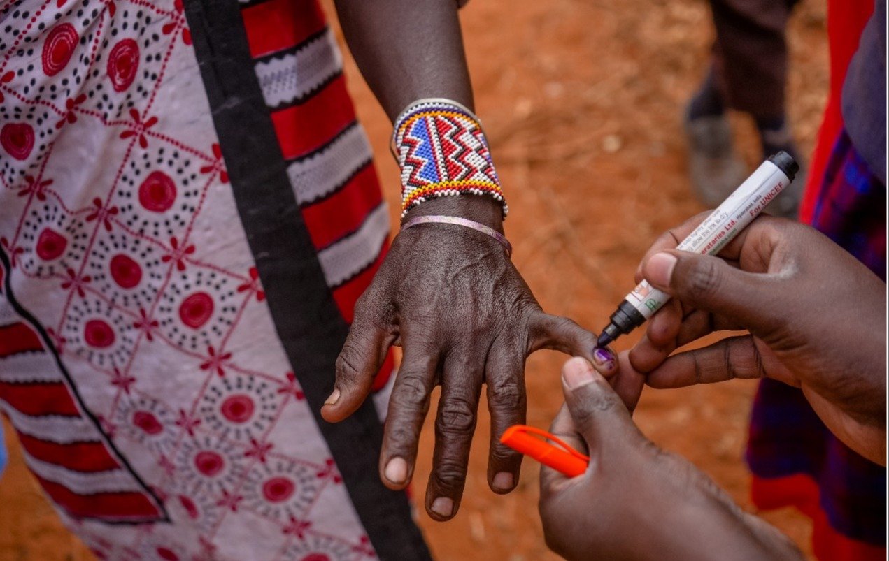 A person marks finger nail of an indigenous person