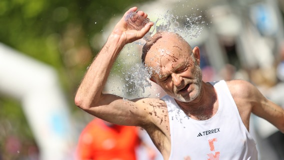 Teilnehmer des Hamburger Marathons überschüttet sich mit Wasser © NDR Foto: Hanno Bode
