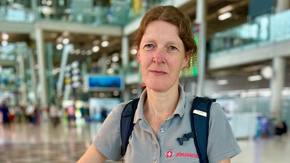 Die Johanniter-Mitarbeiterin Birte Kötter steht am Flughafen. © Paul Hahn/Johanniter Foto: Paul Hahn