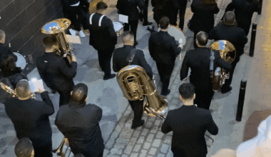 The Most Spanish Thing Ever- A Musician Marching During a Semana Santa Celebration in Alcala del Valle Has a Live Football Match Streaming on His Phone On Top of His Music Notes During the Procession