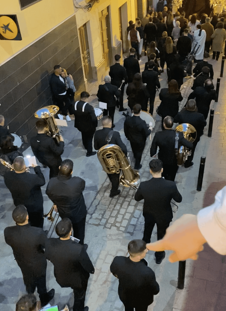 The Most Spanish Thing Ever- A Musician Marching During a Semana Santa Celebration in Alcala del Valle Has a Live Football Match Streaming on His Phone On Top of His Music Notes During the Procession