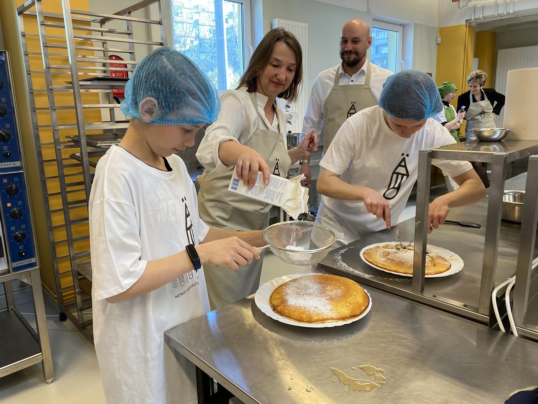 Austrian ambassador Bernadette Klösch finishes up Kaiserschmarren by dusting it with powdered sugar