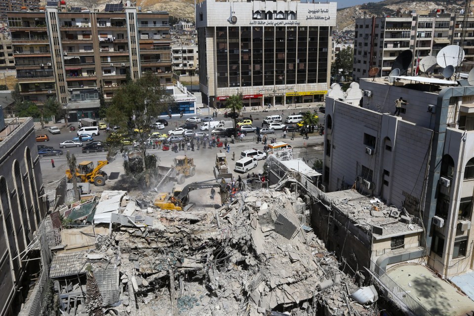 Rescue workers clearing rubble from a damaged building.