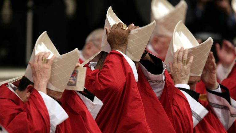 Cardinals hold their hats during a mass presided by [German Cardinal Joseph Ratzinger] in St. Peter's Basilica in the Vatican April 18, 2005. Cardinals will meet later today in the Sistine chapel for the start of the papal conclave.
