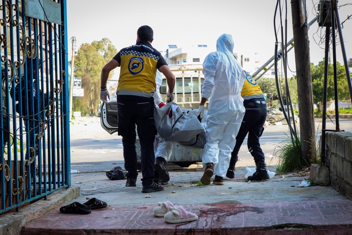 Members of the Syrian White Helmets collect the bodies of people found dead.
